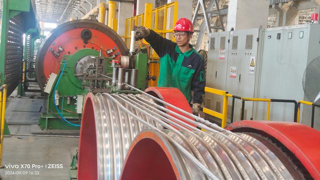 Person standing in a factory with machinery in the background